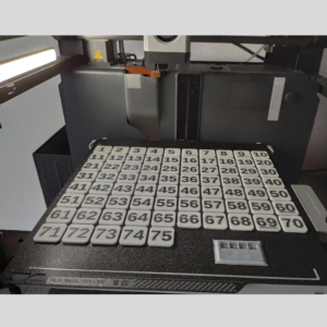 3D printer showing a completed set of 75 number tiles